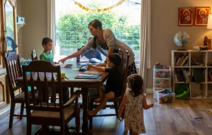 Maureen McKinley helps her children through some study exercises in her family's dining room in Phoenix. McKinley and her husband, Matt, home-school their five children and offer the older children a curriculum that includes Latin. Credit: Jake Kelly